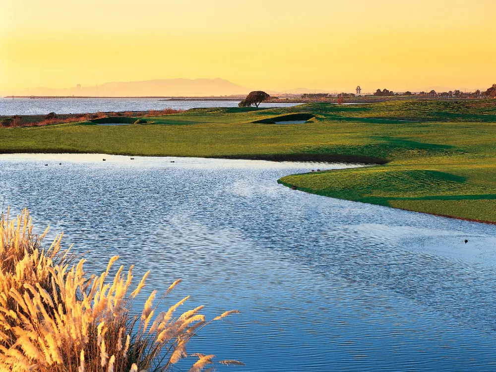 View of 16th green overlooking the pond with views of San Francisco Bay